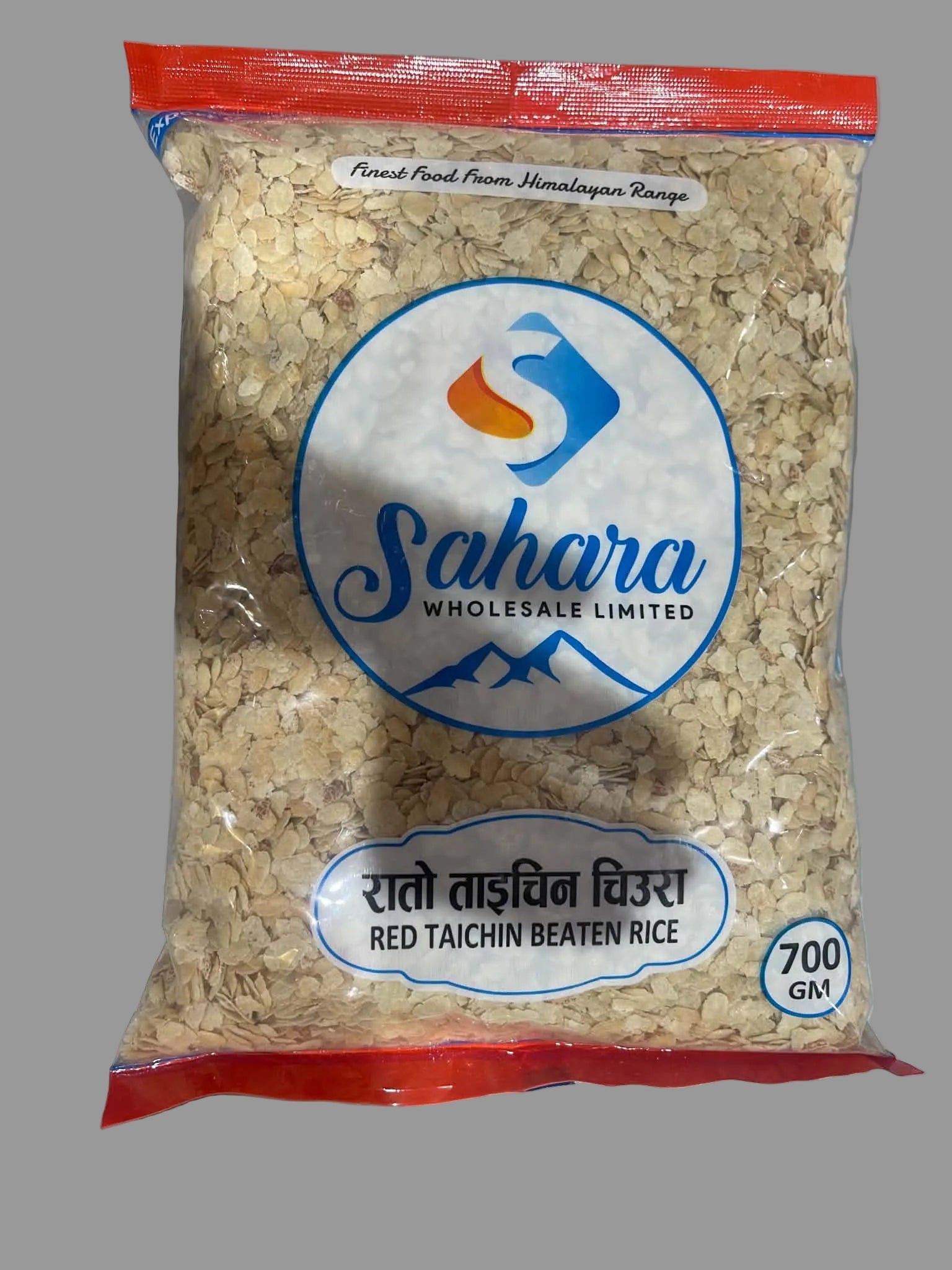 A 700g bag of Sahara Wholesale Limited Red Taichin Beaten Rice (Red Taidchin Wachu) on a gray background. The packaging features a clear window showing the beige-beaten rice inside, with a red top and bottom seal and a prominent blue and white circular logo.