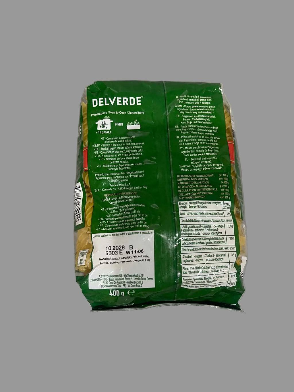 The back of a green bag of Delverde pasta, showing detailed product information, nutrition facts, and barcode in white text, placed on a gray surface.