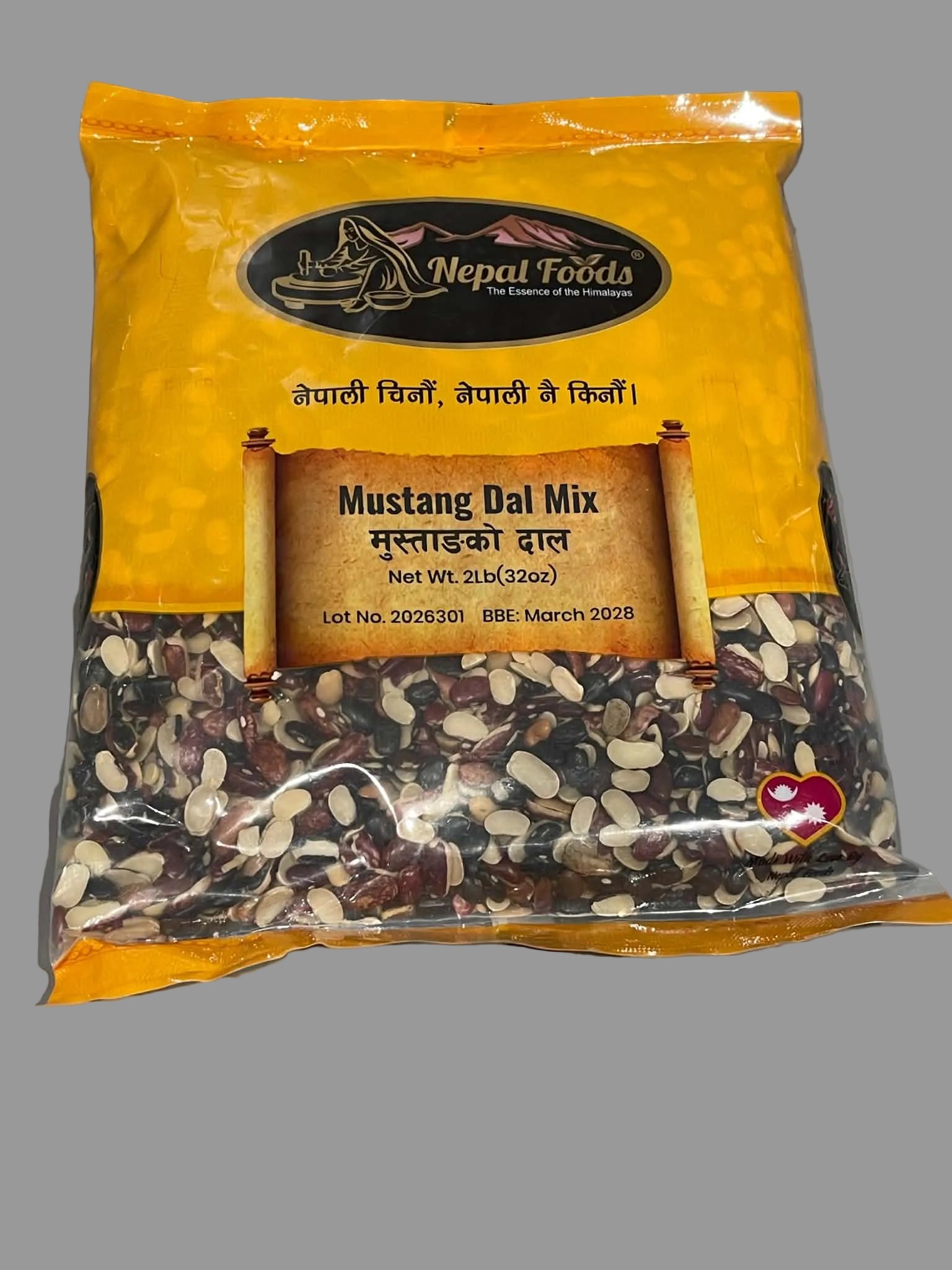 A bag of Nepal Foods Mustang Dal Mix, featuring a bright yellow packaging with a clear lower section showing the mixed lentils inside, set against a neutral gray background.