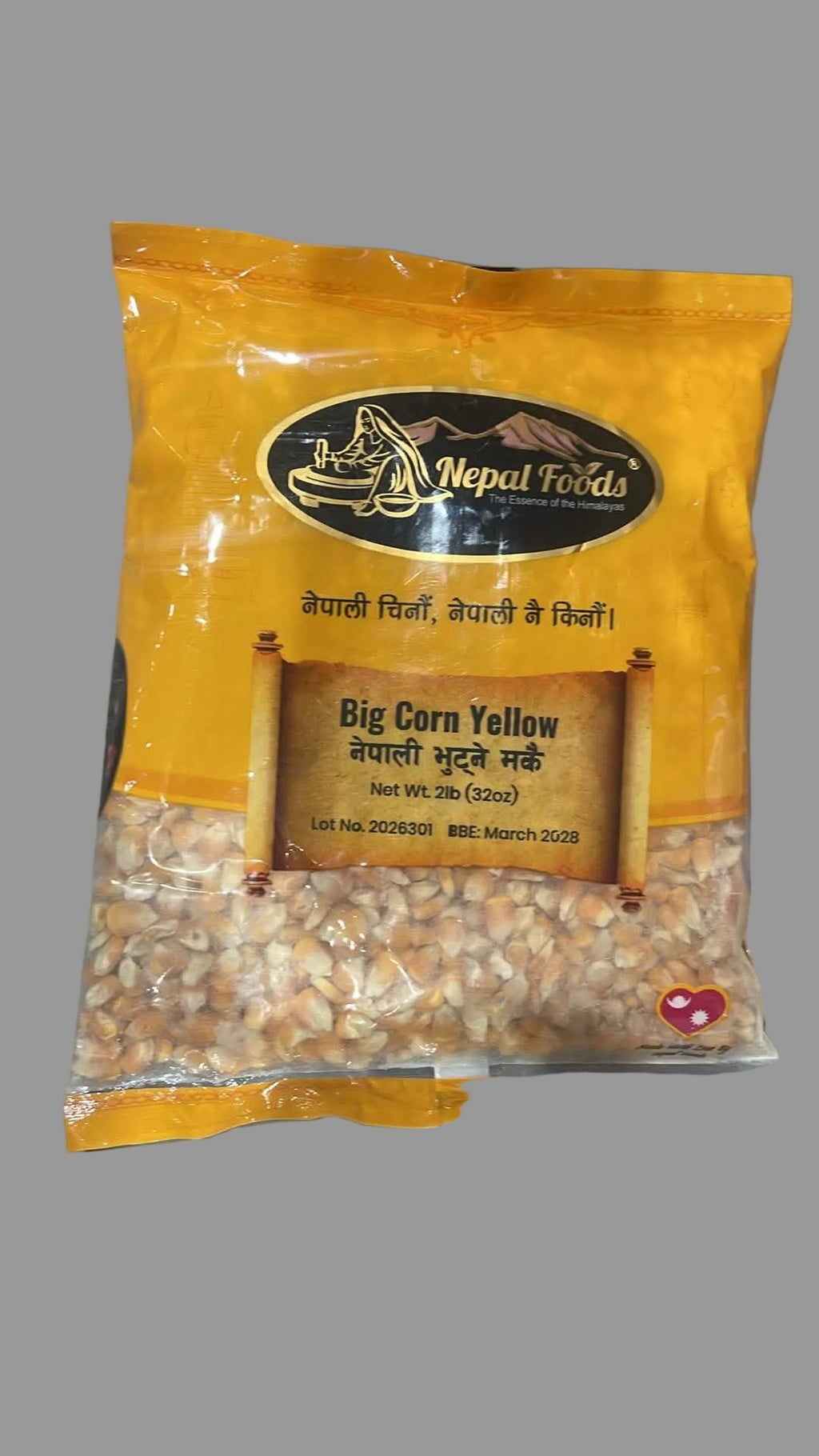 A bag of Nepal Foods Big Corn Yellow (dehydrated corn kernels) in a bright yellow packaging, placed on a gray surface.