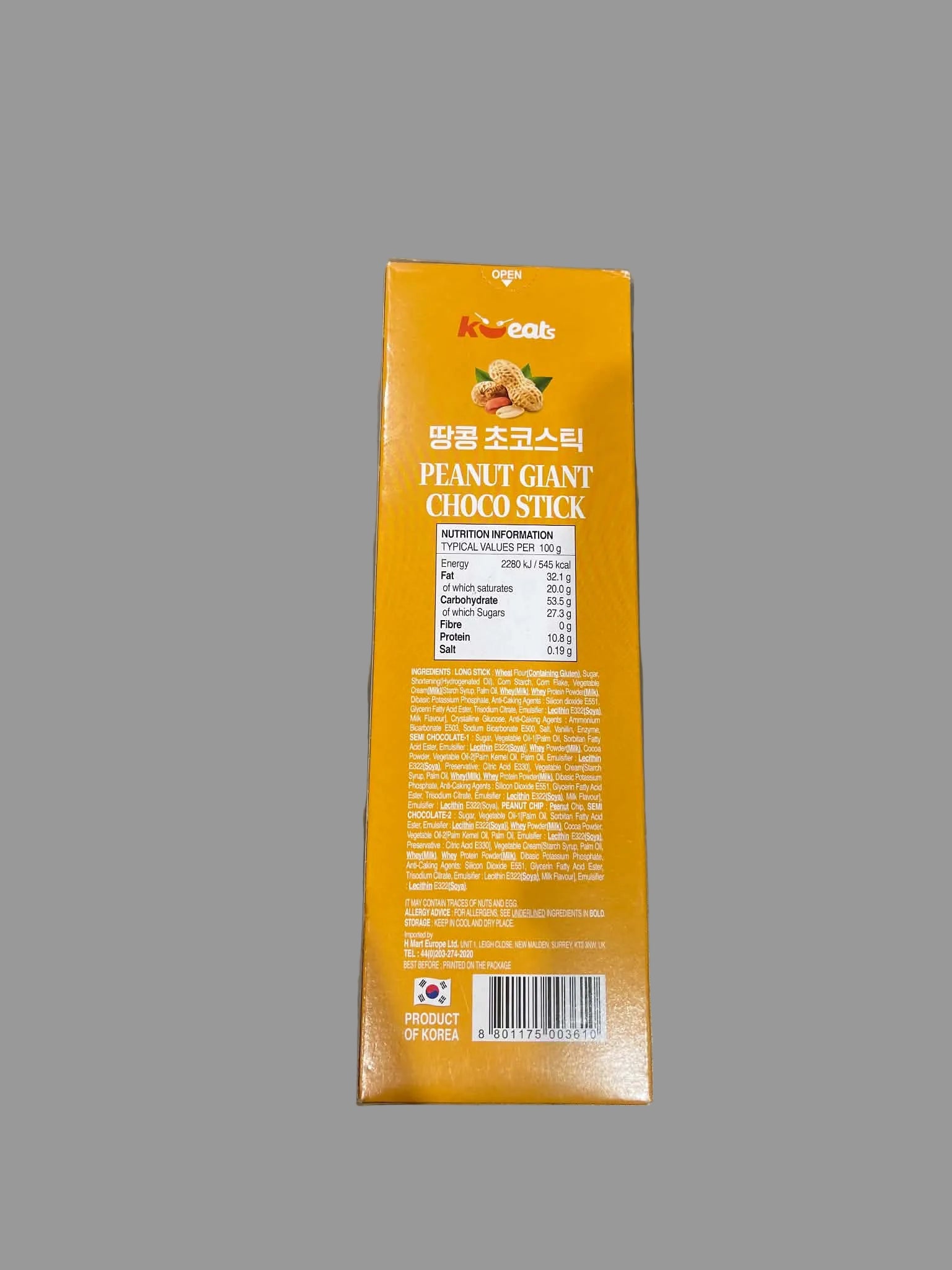 A tall orange rectangular box of KooKab Peanut Giant Choco Stick, showing the back side with product details, nutrition facts, and a barcode, placed on a gray surface.