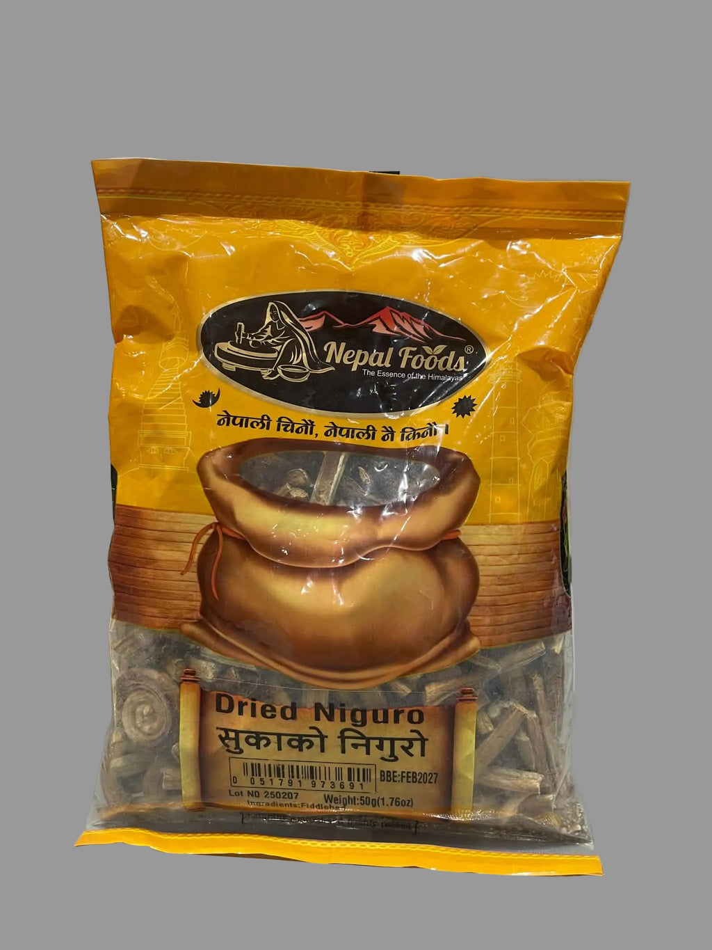 A bag of Nepal Foods Dried Nigro (Sukako Nigro) spice mix, featuring a bright yellow-orange packaging with a picture of a pot of dried spices, set on a gray countertop.