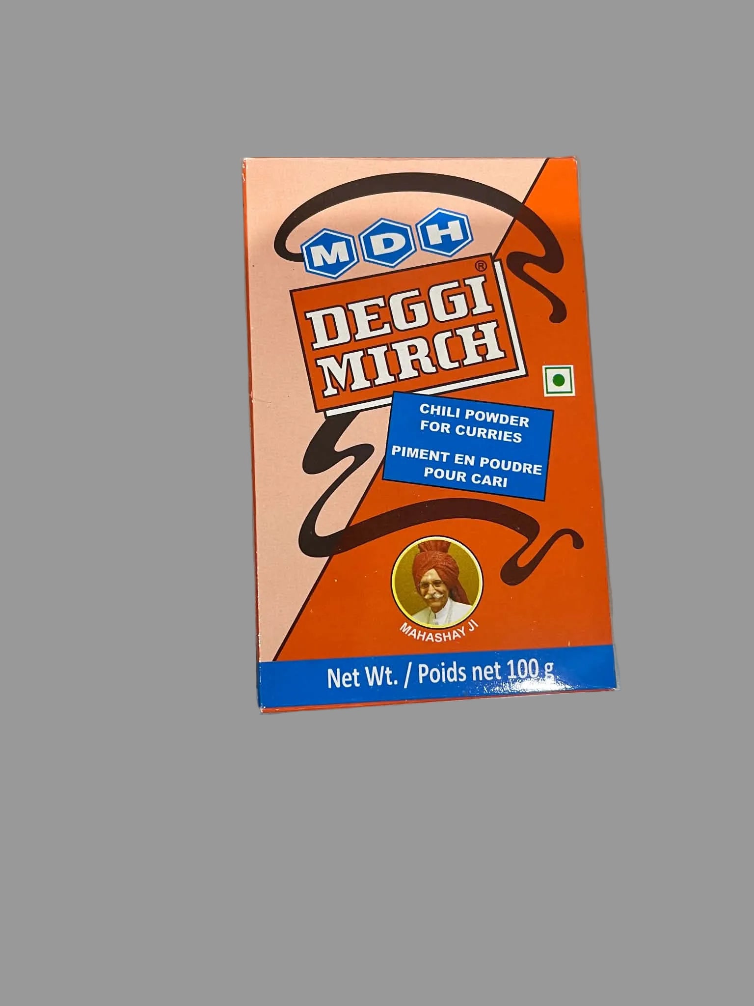 A box of MDH Deggi Mirch chili powder for curries, featuring a bright orange and peach design with blue accents, placed on a gray surface.