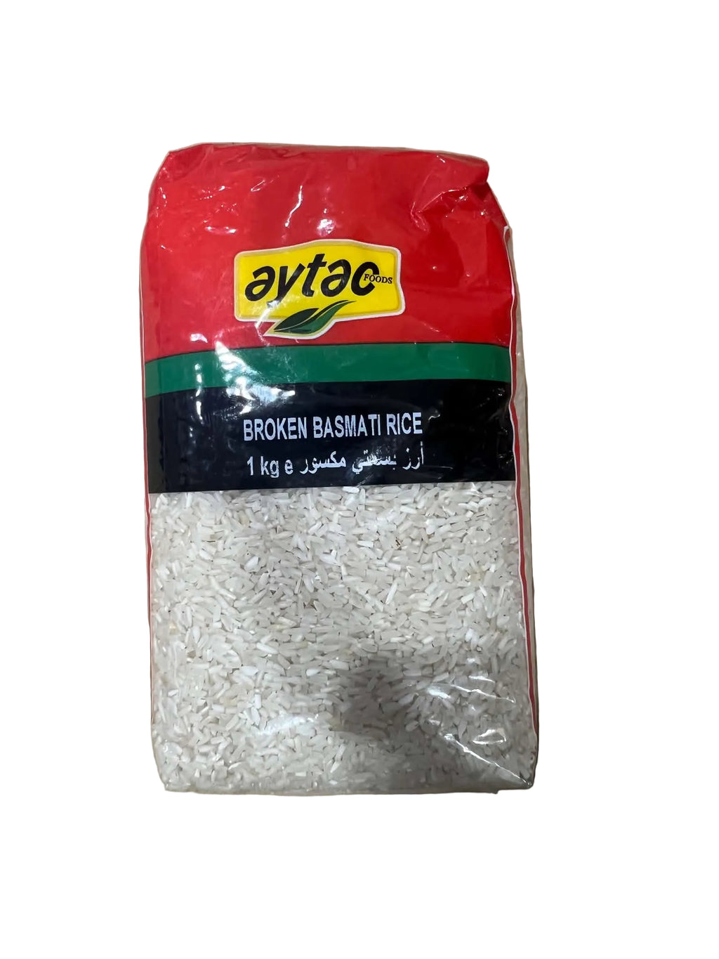 A 1 kg bag of Avto Broket Basmati Rice, showing the white rice grains through a clear window on the left side, with a black, green, and red label and a yellow Avto logo on the right, placed on a brown cardboard background.