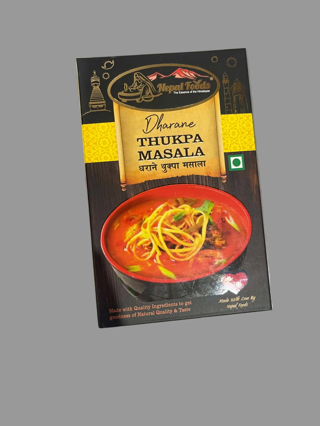 A package of Nepal Table Dharne Thukpa Masala spice mix, featuring a dark brown and gold design with an illustration of a bowl of spicy noodles, photographed on a gray surface.