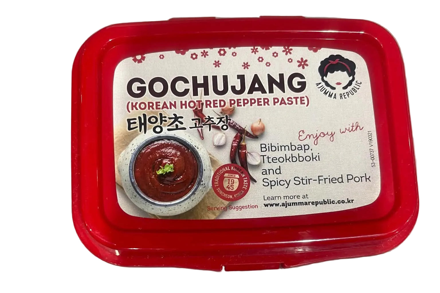 A red plastic tub of Gochujang Korean hot red pepper paste on a gray surface. The front label features a white background with red text and images of the product.