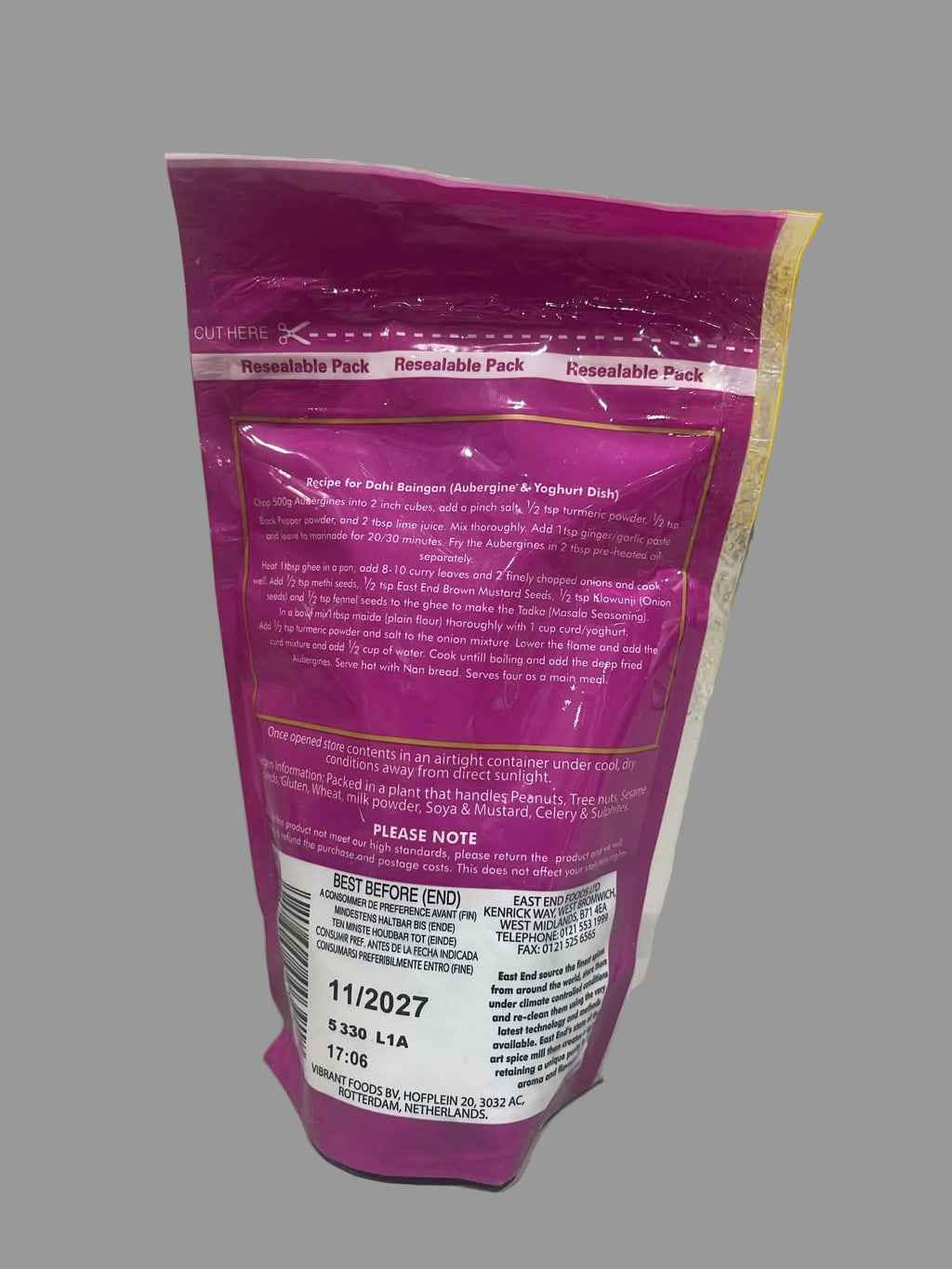 A pink resealable pouch of QuikHeal Resilable Pack wound care product, showing the back of the packaging with text and a barcode, photographed on a white surface with stacked yellow boxes in the background.