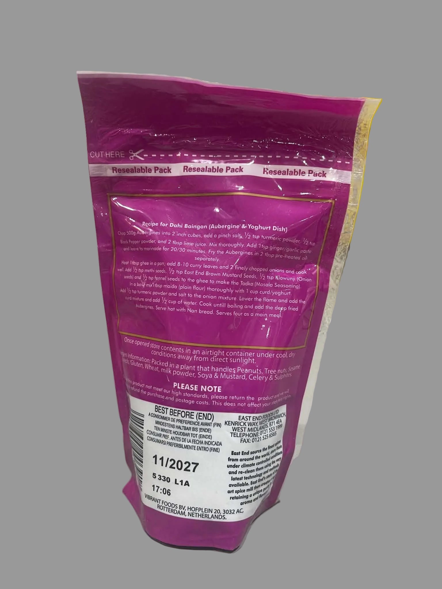 A pink resealable pouch of QuikHeal Resilable Pack wound care product, showing the back of the packaging with text and a barcode, photographed on a white surface with stacked yellow boxes in the background.