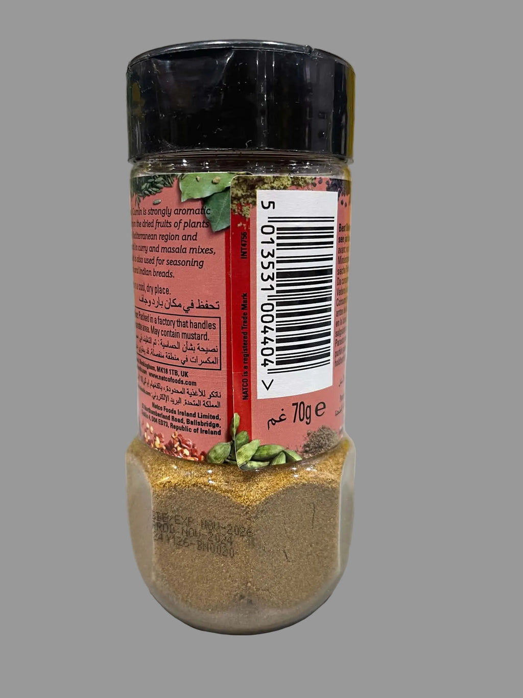 A 700g plastic spice jar with a black lid and a red label, showing the brown seasoning powder inside and green pepper flakes on top, set on a white surface.