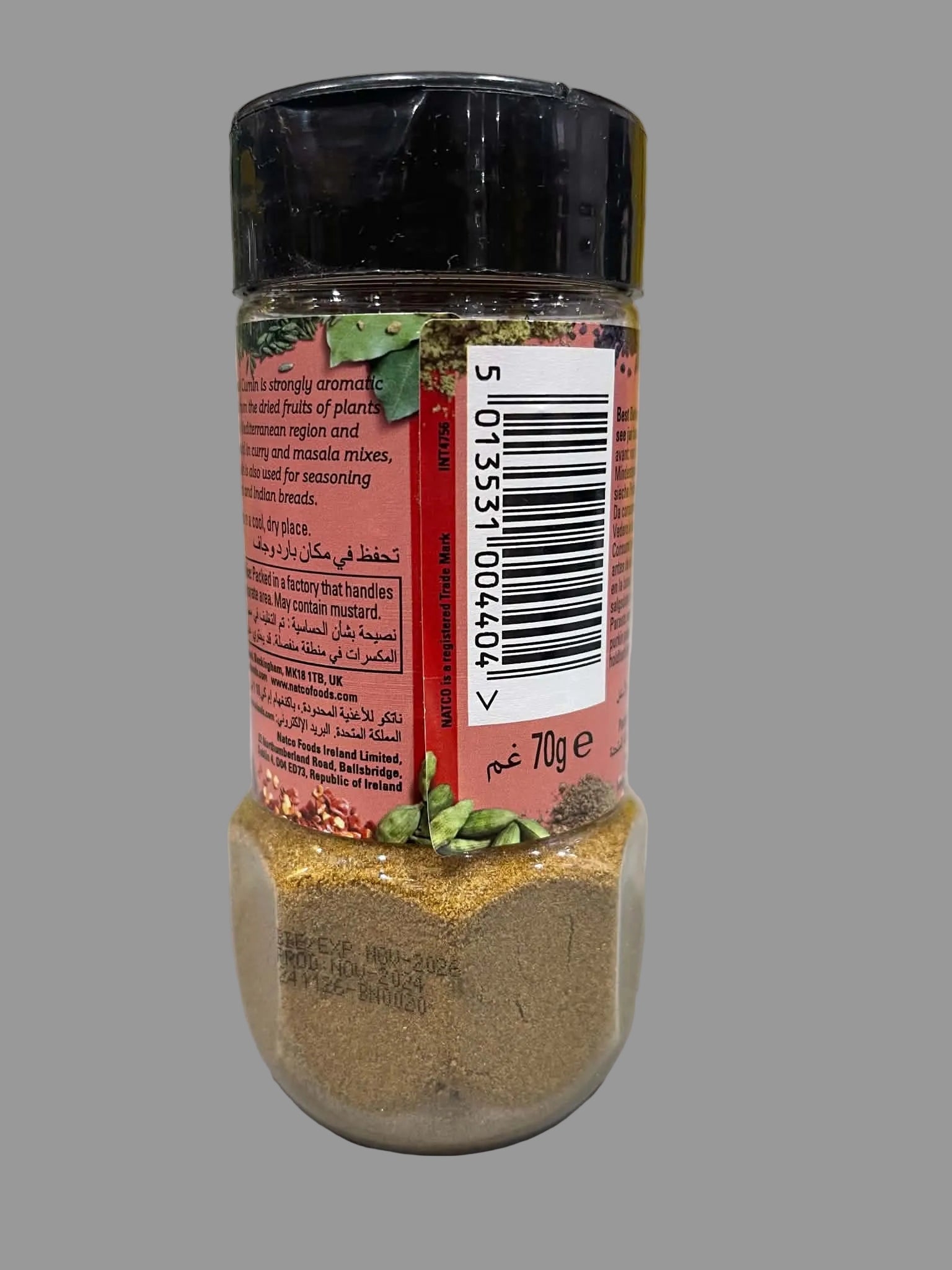 A 700g plastic spice jar with a black lid and a red label, showing the brown seasoning powder inside and green pepper flakes on top, set on a white surface.