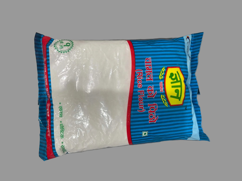 A bag of Kala Dal Dal (rice flour) in blue and white packaging, photographed on a gray surface.