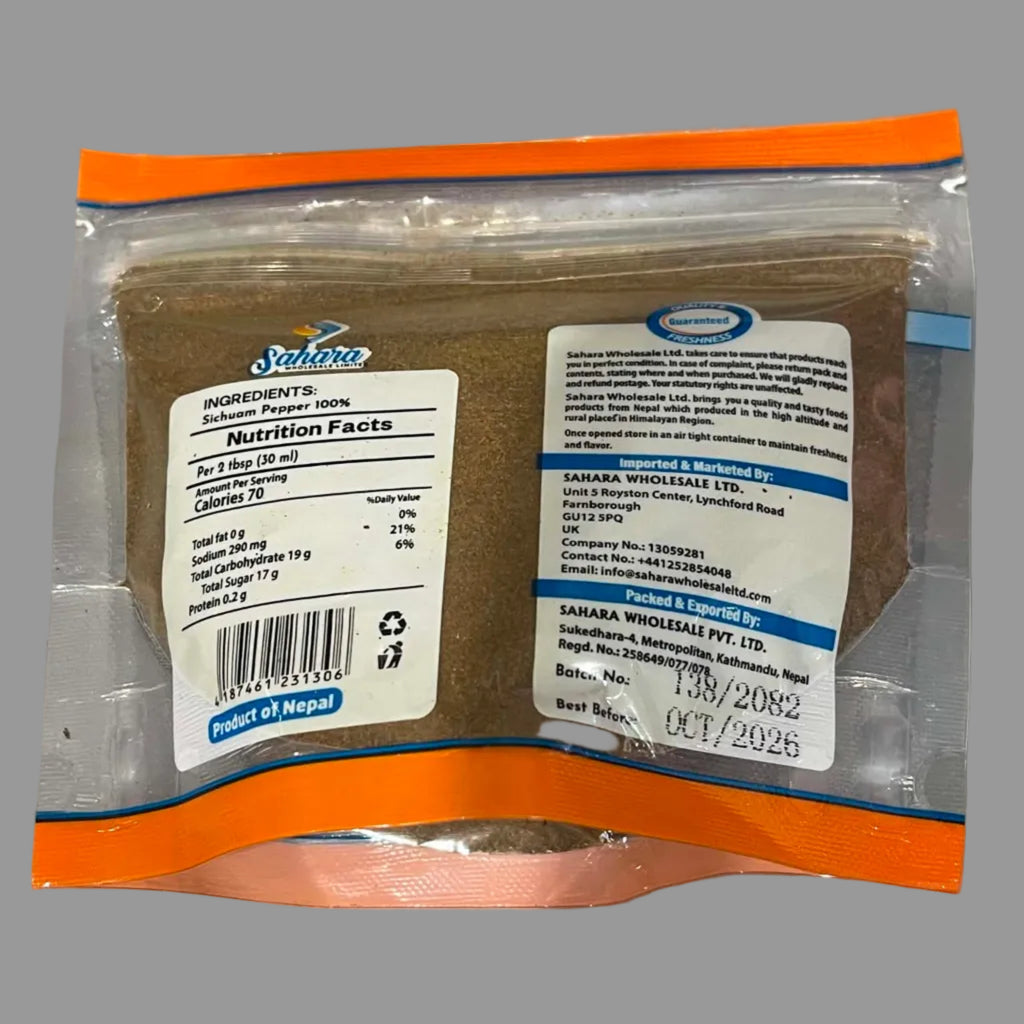 A sealed plastic pouch of Nepal Blue Mountain Tea with orange trim and white labels showing product details, photographed on a gray surface.