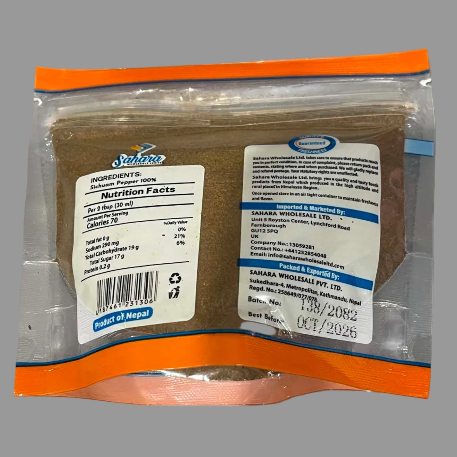 A sealed plastic pouch of Nepal Blue Mountain Tea with orange trim and white labels showing product details, photographed on a gray surface.