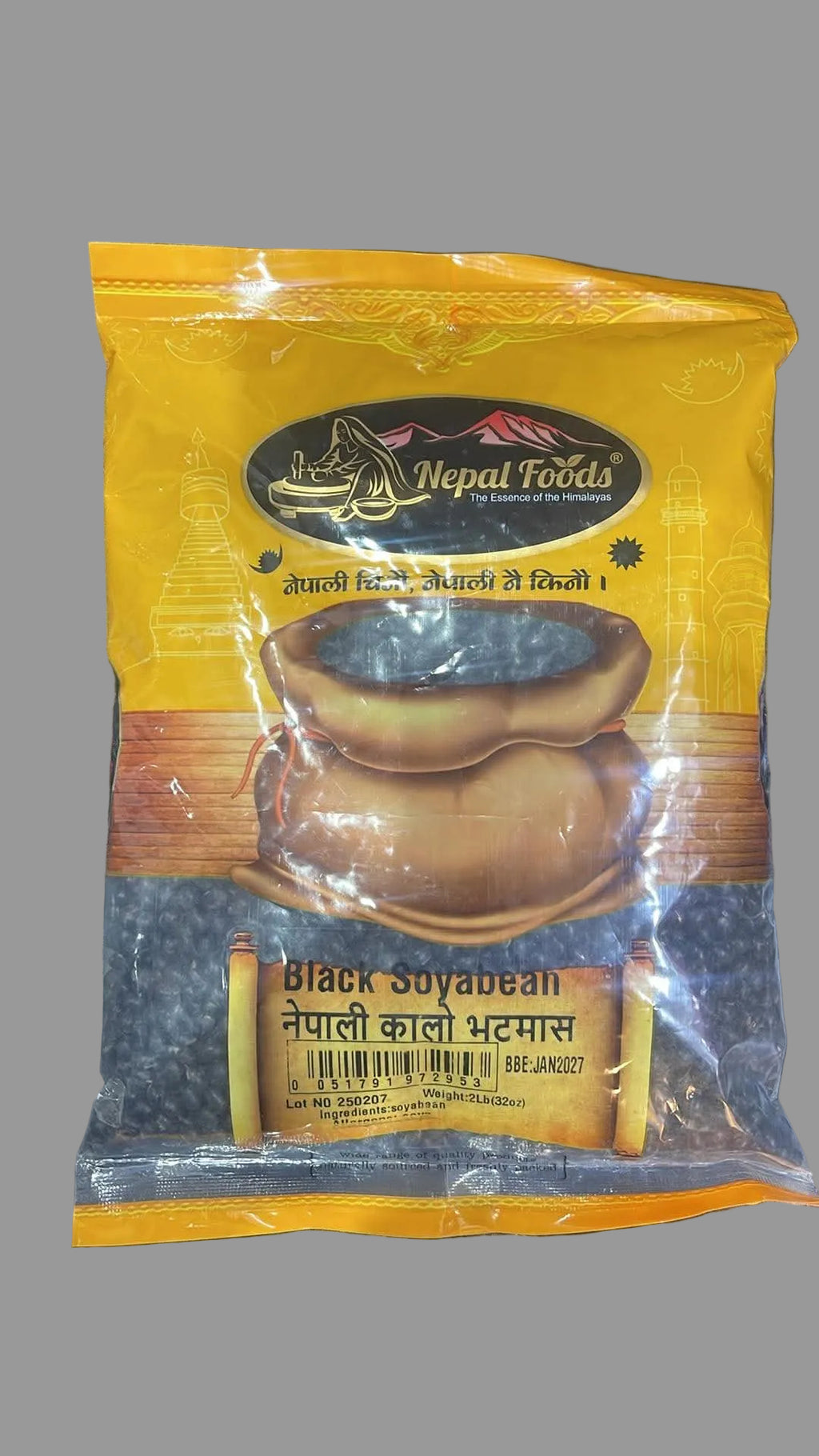 A package of Nepal Foods Black Soyabean, featuring a yellow and brown bag with an illustration of a bowl of black beans, placed on a dark textured surface.