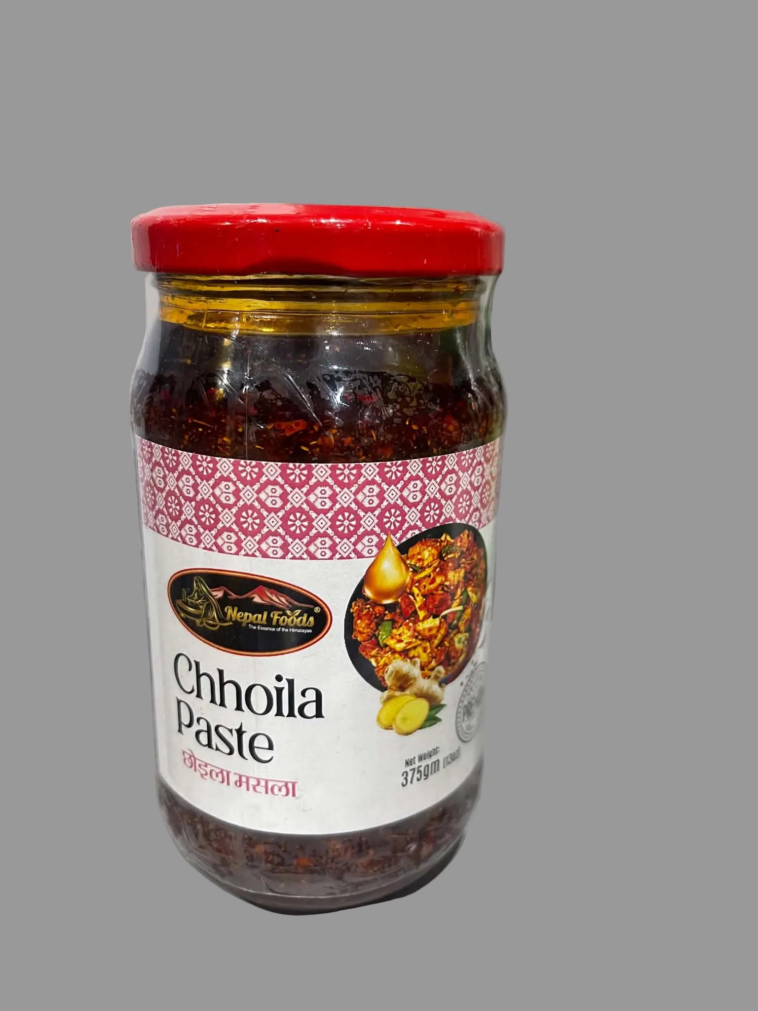 A glass jar of Harjit Singh Chhoila Paste with a red lid and a white label, placed on a white surface with a blurred kitchen background.