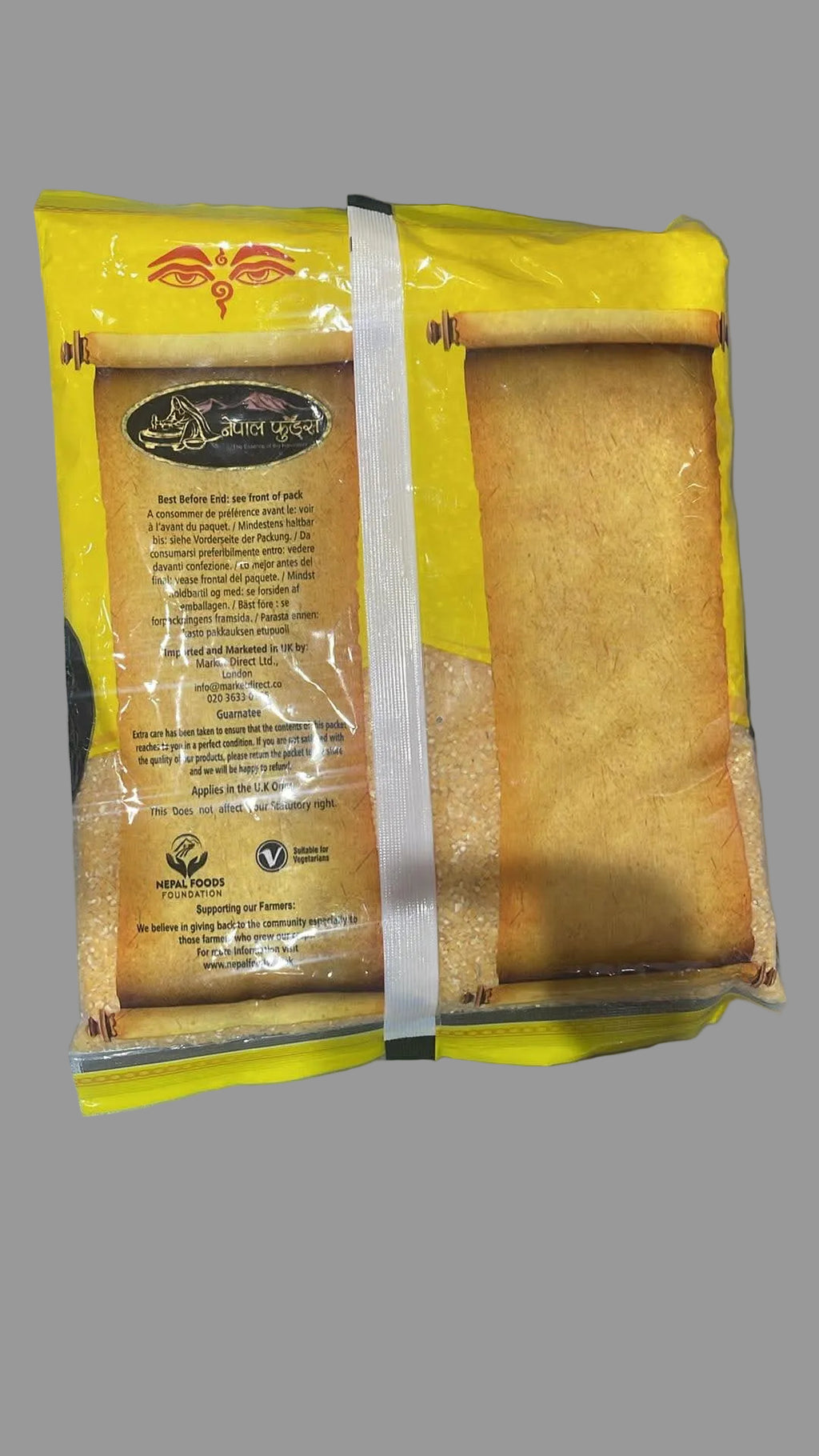 A package of golden-brown flatbreads or tortillas in a yellow and brown paper sleeve, photographed on a gray surface.