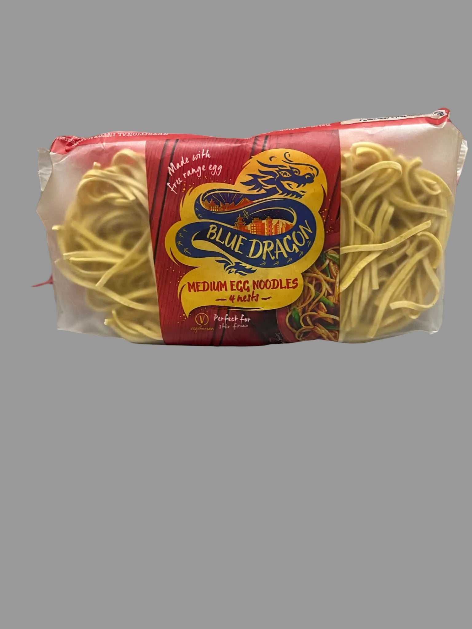 A package of Blue Dragon Medium Egg Noodles in a clear plastic bag with a red and yellow label, showing the yellow noodles inside, placed on a light gray countertop.
