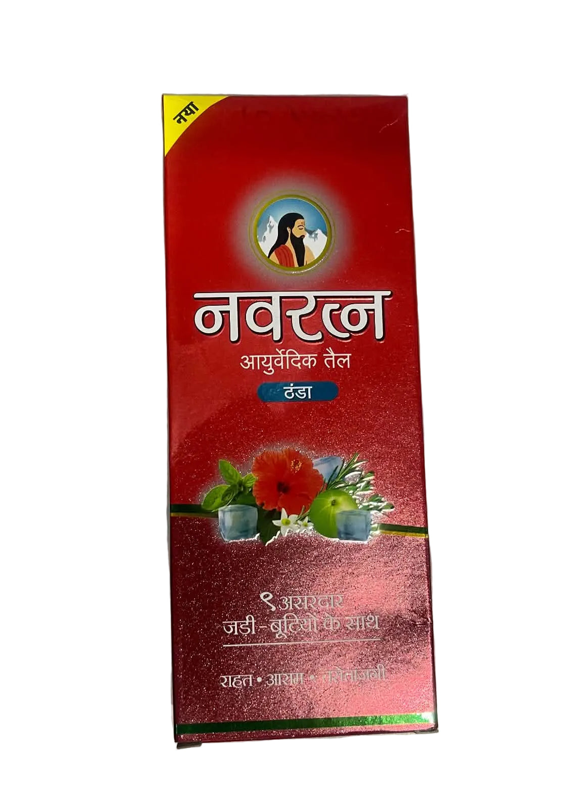 A red rectangular box of Navrakna Ayurvedic Teel, featuring Hindi text and illustrations of herbs and flowers, photographed on a gray surface.