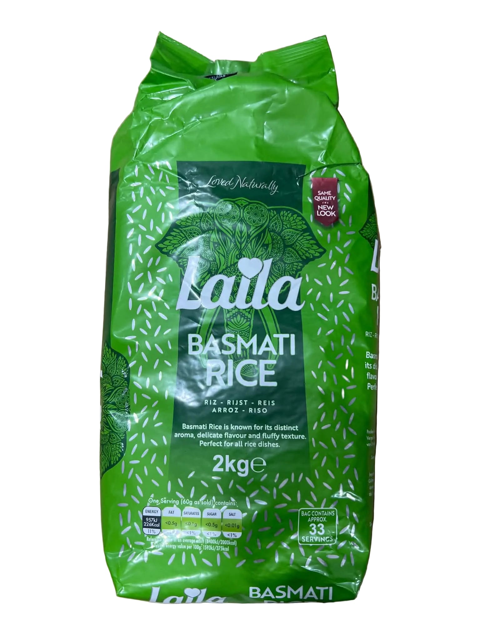 A 2kg bag of Lalal Basmati Rice on a brown cardboard box. The packaging is bright green with white text and patterns, and a small red 'Fair Trade' badge is visible on the bottom right.