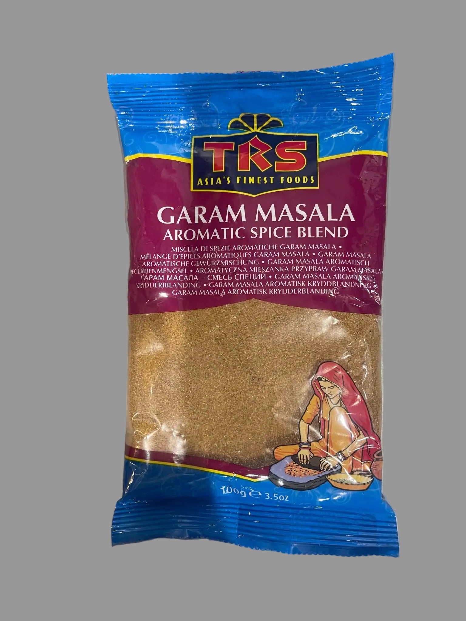 A 100g package of TKS Garam Masala Aromatic Spice Blend, featuring a blue and maroon bag with a clear window showing the brown spice powder inside.