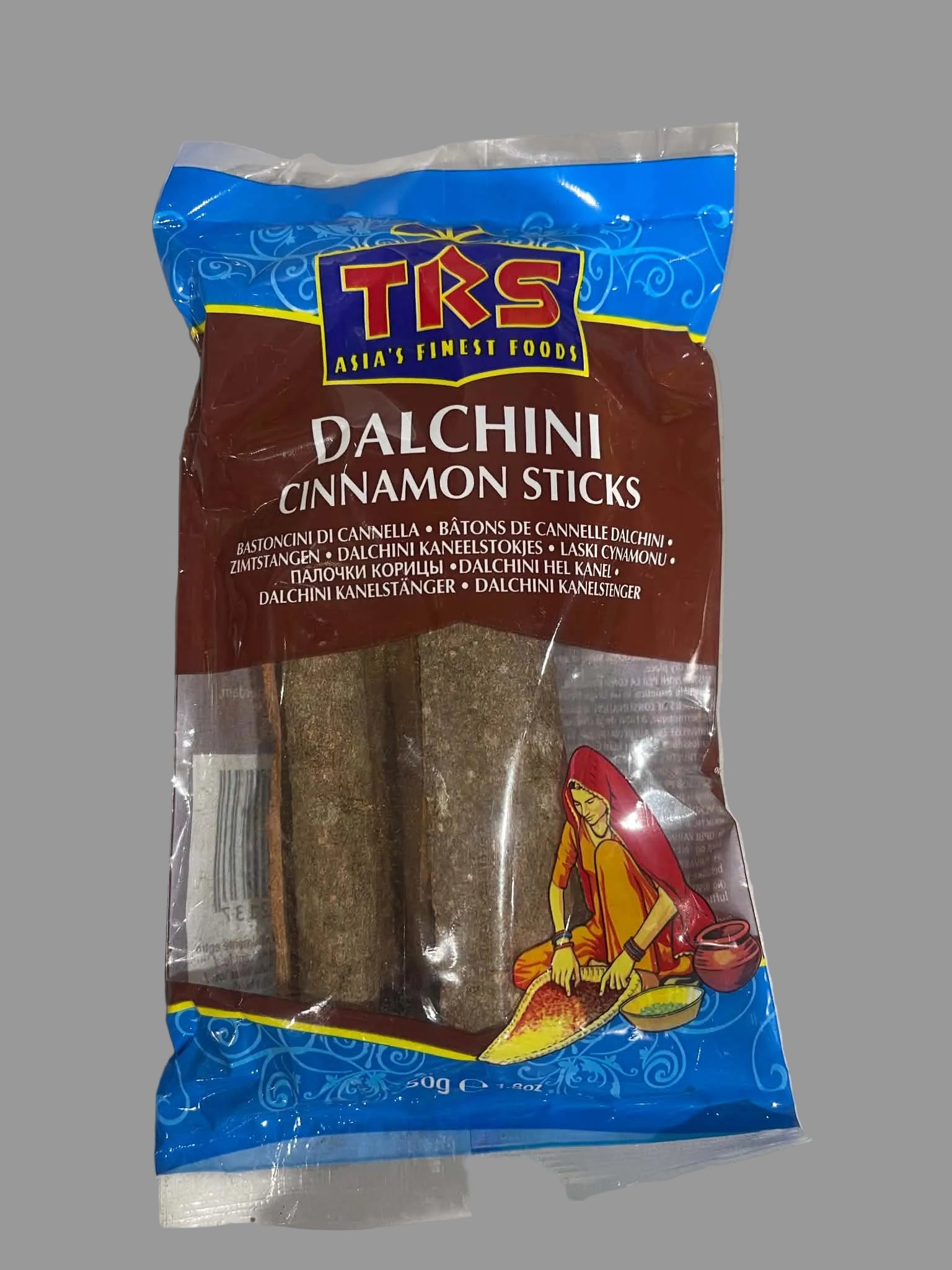 A package of TKS Dalchini Cinnamon Sticks, featuring a blue and brown bag with a clear window showing the cinnamon sticks inside, photographed on a light gray surface.