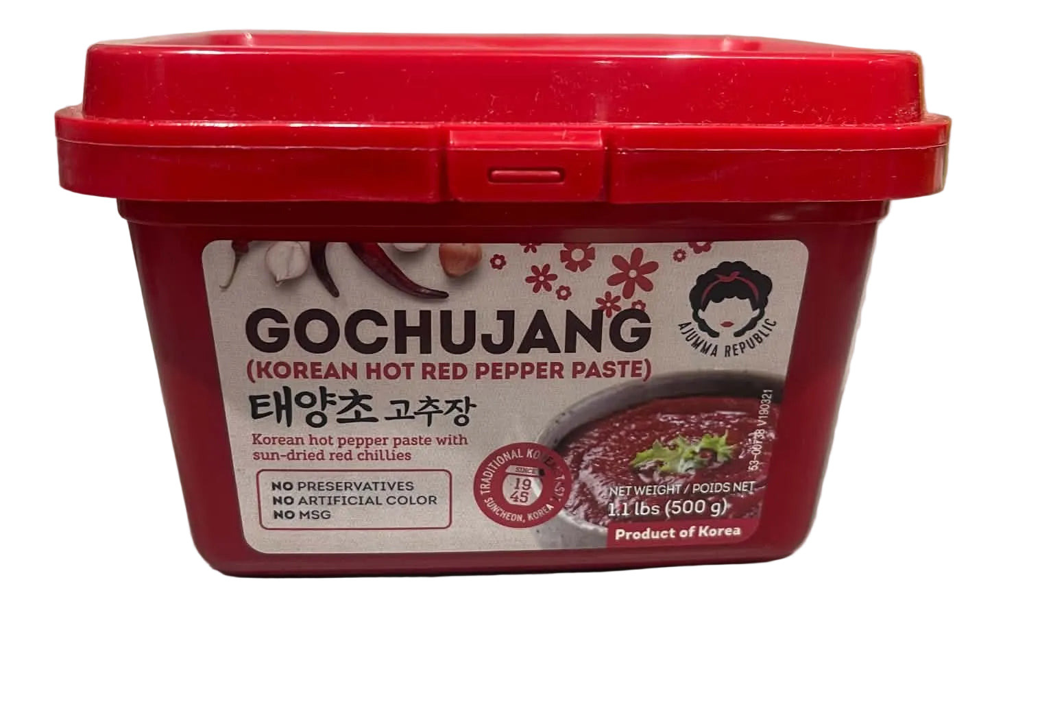 A red plastic tub of Gochujang Korean hot red pepper paste on a light gray countertop with a marble backsplash in the background.