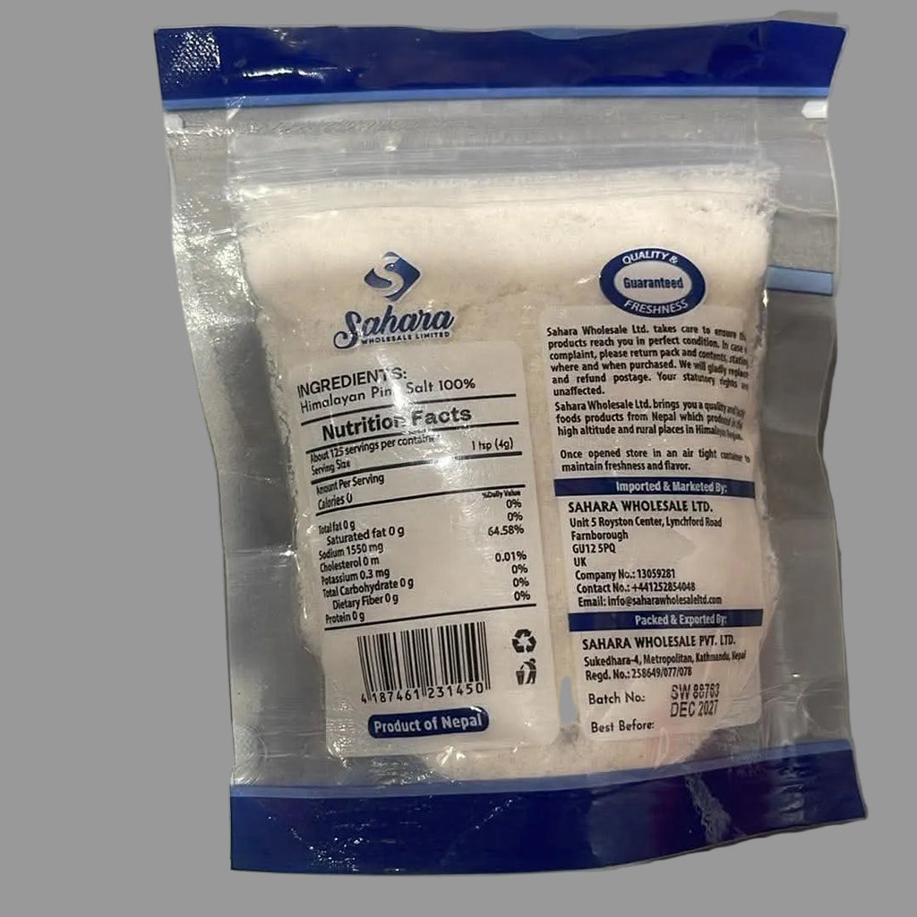 A package of Sahara White Sugar in a clear plastic bag with blue seals and a white label, photographed on a gray surface.