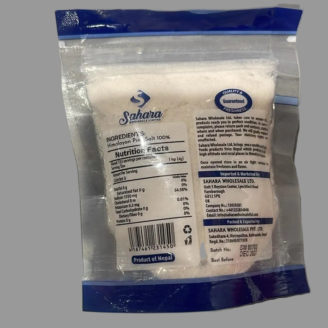 A package of Sahara White Sugar in a clear plastic bag with blue seals and a white label, photographed on a gray surface.